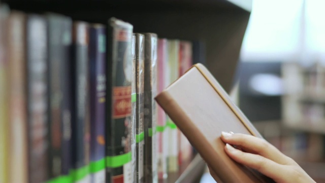 亚洲女学生在一所大学图书馆找书和取书。教育的概念。视频素材