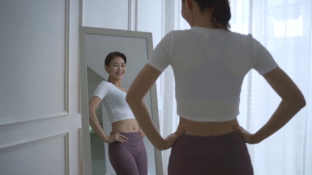一位中年妇女对着镜子检查自己的身体视频下载