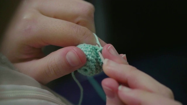 一个女人的手用线和钩针缝纫的特写。视频下载