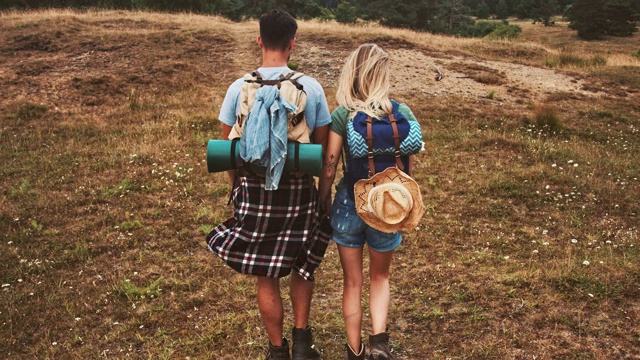 一对年轻夫妇度假时在田野上散步视频素材
