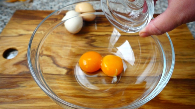蛋黄落在碗里。缓慢的运动。视频素材
