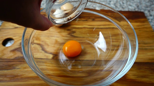 蛋黄落在碗里。缓慢的运动。视频素材