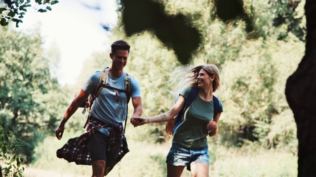 无忧无虑的年轻夫妇在森林里徒步旅行视频素材