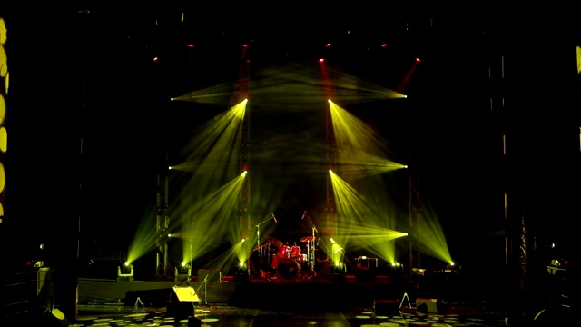 黄色和红色的舞台灯光。现场，舞台灯光与聚光灯和烟雾。视频下载