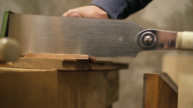 男木匠用手锯锯木元素。4 k视频下载
