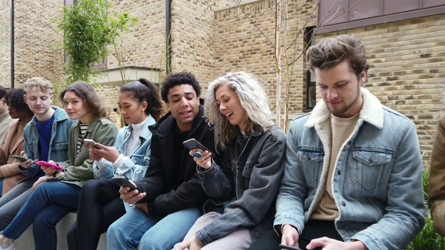 一群青少年朋友专注于自己的智能手机在社交媒体上发短信视频素材