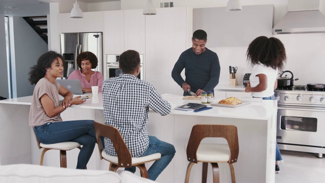 快乐的黑人家庭在他们的厨房岛，聊天和准备家庭聚餐视频素材