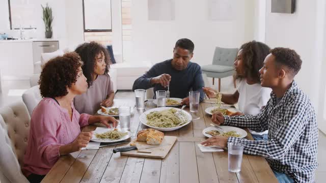 黑人家庭坐在餐桌边聊天，近距离观察视频素材