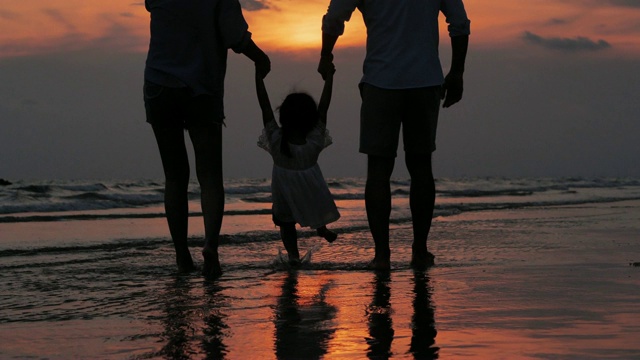 幸福的一家人在海滩上散步的剪影。快乐的一家人在海滩上享受暑假。假期——iStock视频素材
