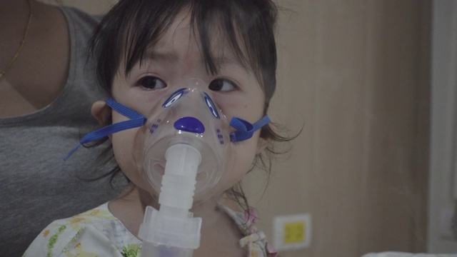 一个亚洲小女孩正在医院接受雾化吸入治疗。视频素材