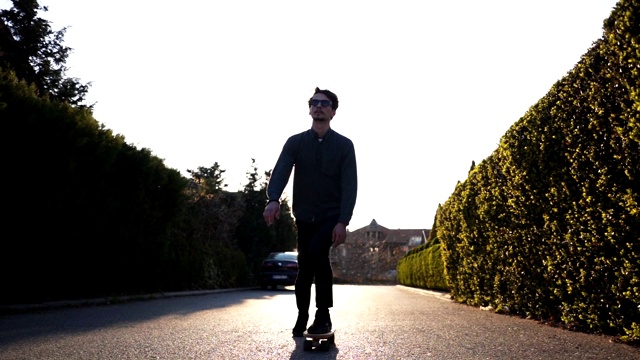 在阳光明媚的城市街道上玩滑板的嬉皮士视频素材