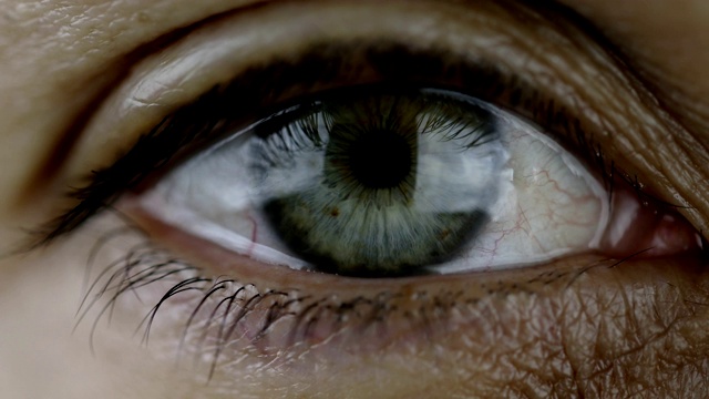 美丽的绿色眼睛看着相机，眼皮闭上又睁开。视频素材