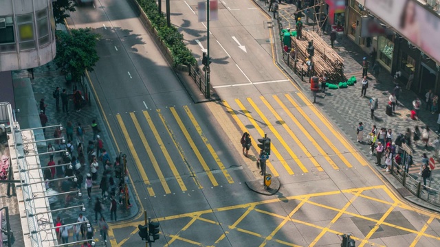 在中国香港尖沙咀区，人们和出租车穿过一个非常繁忙的十字路口视频下载