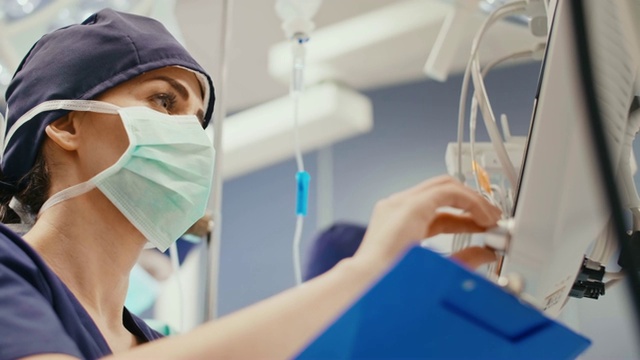一位女性麻醉师正在记录最新情况视频下载