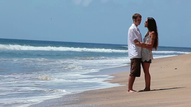 情侣们紧紧拥抱着海浪。视频下载