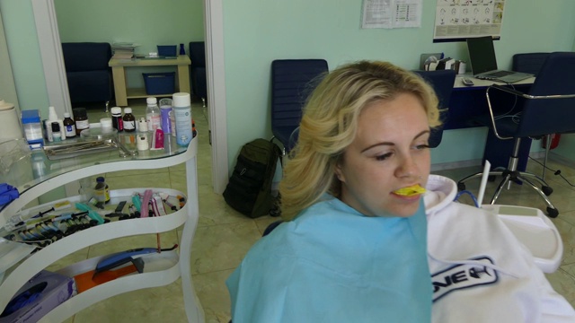 牙医接待处的那个女孩。牙医在牙科诊所为病人治疗牙齿。视频素材