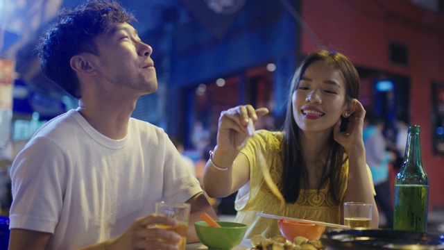 年轻夫妇在街头吃着好玩的食物视频素材