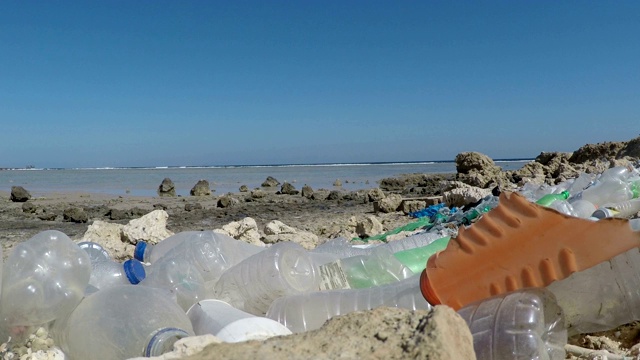 塑料垃圾堆积在海边。视频素材