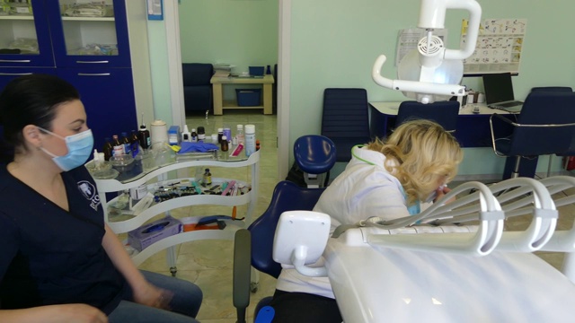 牙医接待处的那个女孩。牙医在牙科诊所为病人治疗牙齿。视频素材