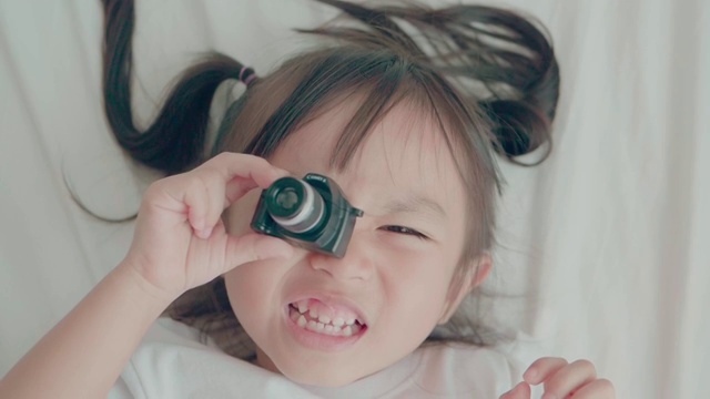 可爱的小女孩在周末用积极的情绪玩摄像机的慢镜头视频素材