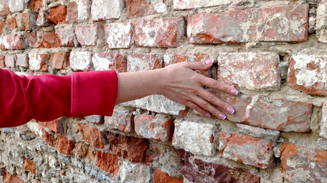 4K女人的手在旧砖墙上移动。滑动。性感动人。坚硬的石头表面。视频素材