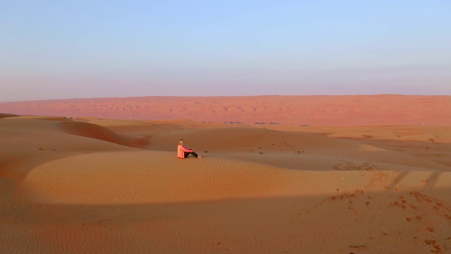 空中游客坐在沙漠中的沙丘上视频素材
