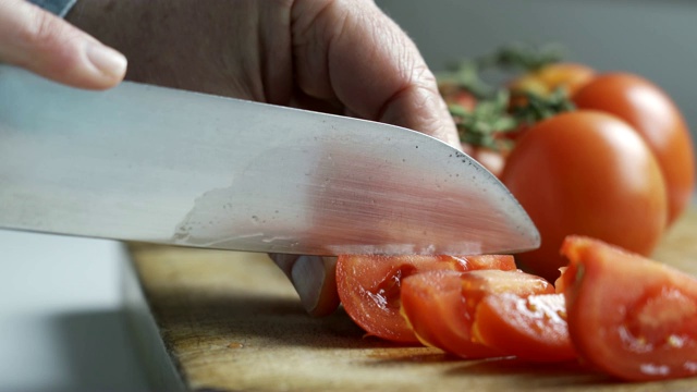 男人用刀切西红柿的特写镜头视频下载
