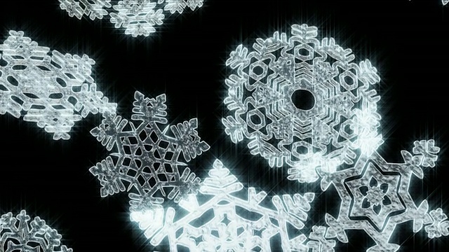 巨大的圣诞雪花在黑色的背景下飘落。Loopable。视频下载