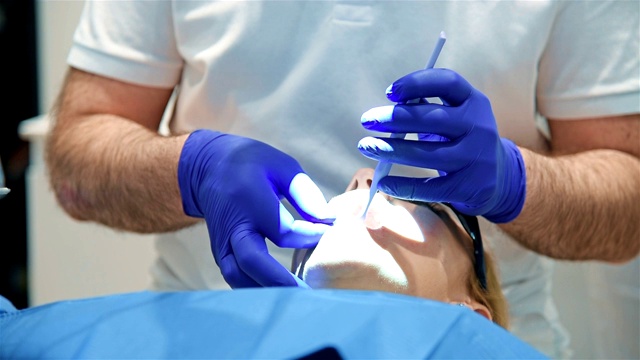 牙医正在治疗一位女病人。视频素材