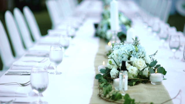 在浪漫的户外婚礼桌上，鲜花和蜡烛放在桌子上。视频素材