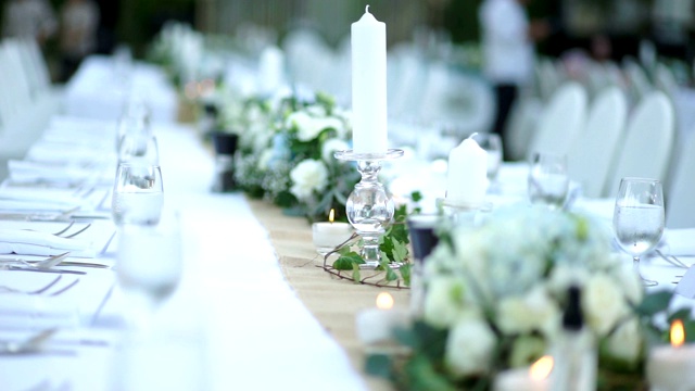 女士多莉右边的婚礼装饰与鲜花和蜡烛在桌子和椅子上为客人。视频素材