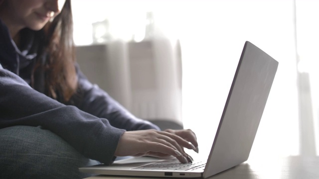 在笔记本电脑上打字的女人，在家工作视频素材