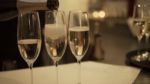 侍者把香槟倒进玻璃杯里，特写。——股票视频视频下载