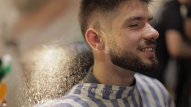理发师在理发店背景上向客户喷洒香水视频素材