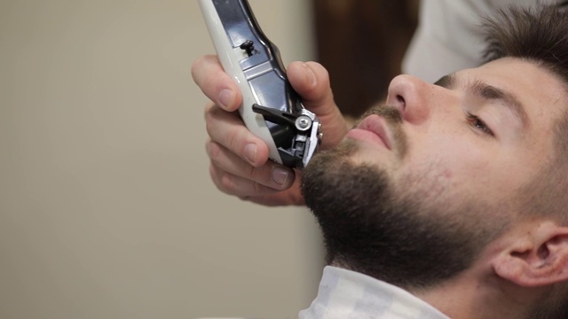 留黑胡子的顾客在理发店刮胡子。新郎,男性视频素材