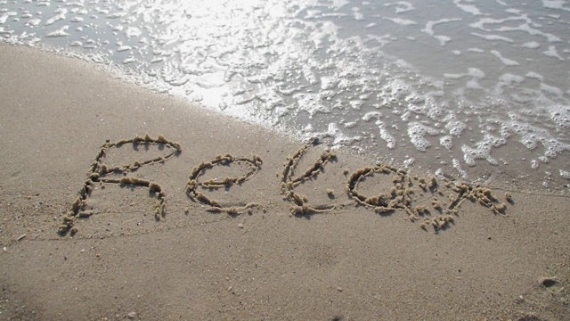 写在沙滩上的“放松”字。视频下载