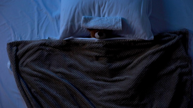 玩具泰迪熊躺在床下，用毛巾盖着额头，发烧乏力视频下载