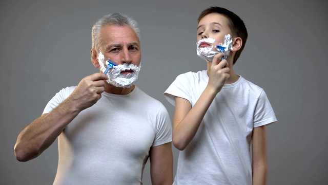 快乐的成年男子和十几岁前的男孩刮胡子，教孩子做男人，早上的仪式视频下载