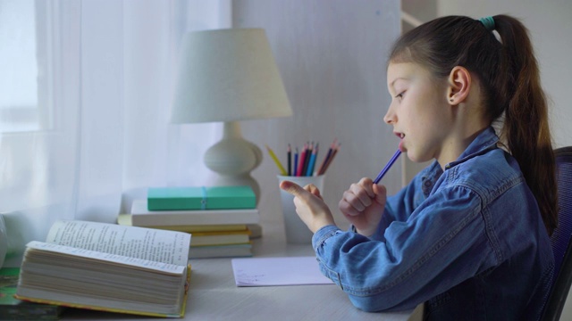 一个小女生在做作业的时候嚼着笔，用手指数数视频素材