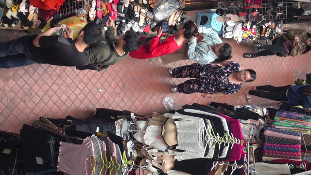 服装市场摊位在越南正上方高角度观看。河内市东轩市场，妇女在买卖。视频素材