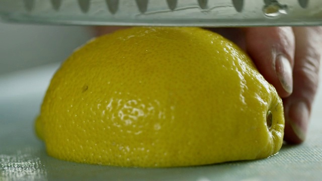 一位年长的白人妇女用菜刀在切菜板上切柠檬视频素材