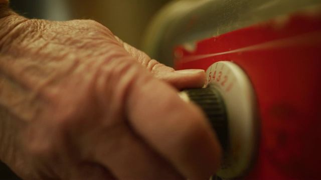 在一个商业厨房/制造设备中，一位老年妇女的手通过拨号打开一个商业燃烧器视频素材