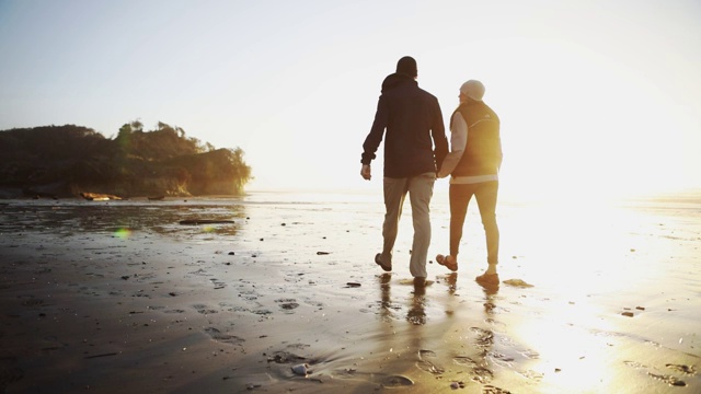 成熟的夫妇漫步在日落俄勒冈海岸海滩视频下载