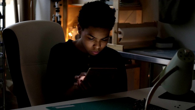 一个十几岁的男孩用平板电脑研究信息视频素材