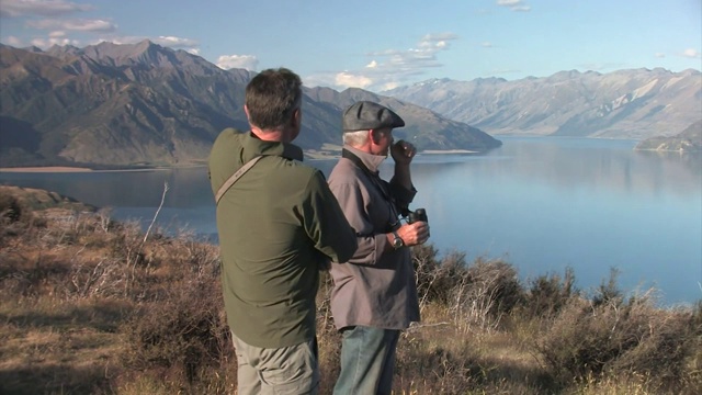 新西兰。南岛。两名男子在瓦纳卡附近的山坡上行走。编辑只使用。视频下载