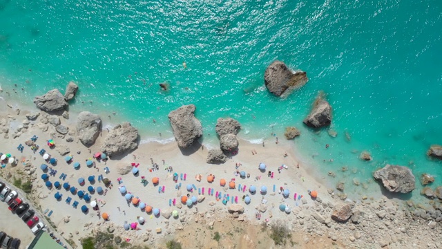 图片:游客们在躺椅上放松，在绿松石般的大海中游泳视频素材