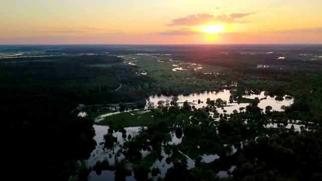 日落时河边美丽的泛水草地。鸟瞰图。视频下载