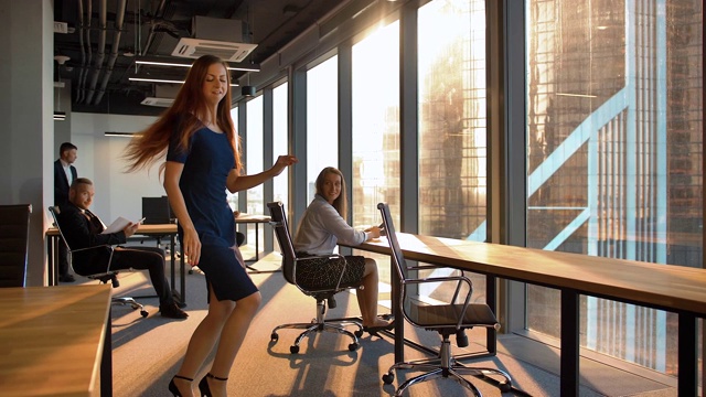 迷人的商务女性在现代办公室跳舞视频素材
