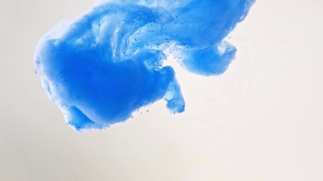 蓝色丙烯酸颜料在溶于水时滴下的照片，近景。抽象的背景。丙烯酸云在液体中旋转。抽象的图案。蓝色墨水在水里。视频素材