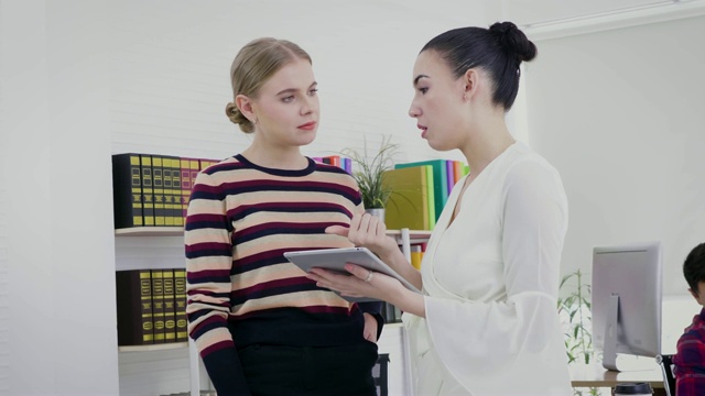 两个年轻女性创意业务同事讨论和头脑风暴在办公室的新业务项目，公司团队工作的同事概念视频素材